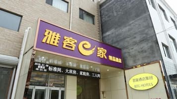 Un hotel con un letrero púrpura y un cartel amarillo que indica que pertenece a la cadena BIG HOTELS.