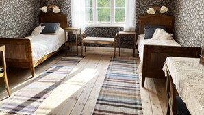 A room with two wooden beds, a small table, a bench, and a window with a view of trees. - Summer house with secluded location in Julita   SE14028 (Julita)