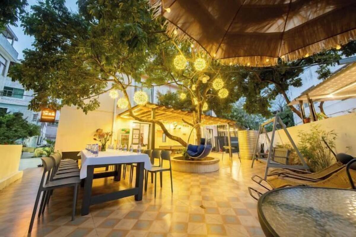An outdoor dining area with a covered seating area, tables, and chairs.