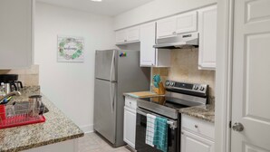A kitchen with white cabinets, a stainless steel refrigerator, a built-in oven, and a granite countertop. - Luxury upgraded, high ceiling home near Domain, high tech corrida, businesses. (Austin)