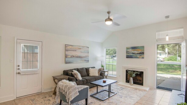 A spacious living room with a fireplace, a ceiling fan, and a large window. - Luxury upgraded, high ceiling home near Domain, high tech corrida, businesses. (Austin)
