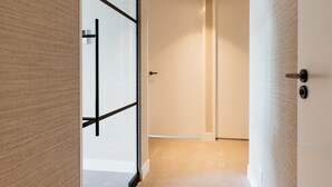 A modern interior with a wooden wall, a glass partition, and a white door. - 3-bedroom Holiday Home in Den Haag (The Hague)