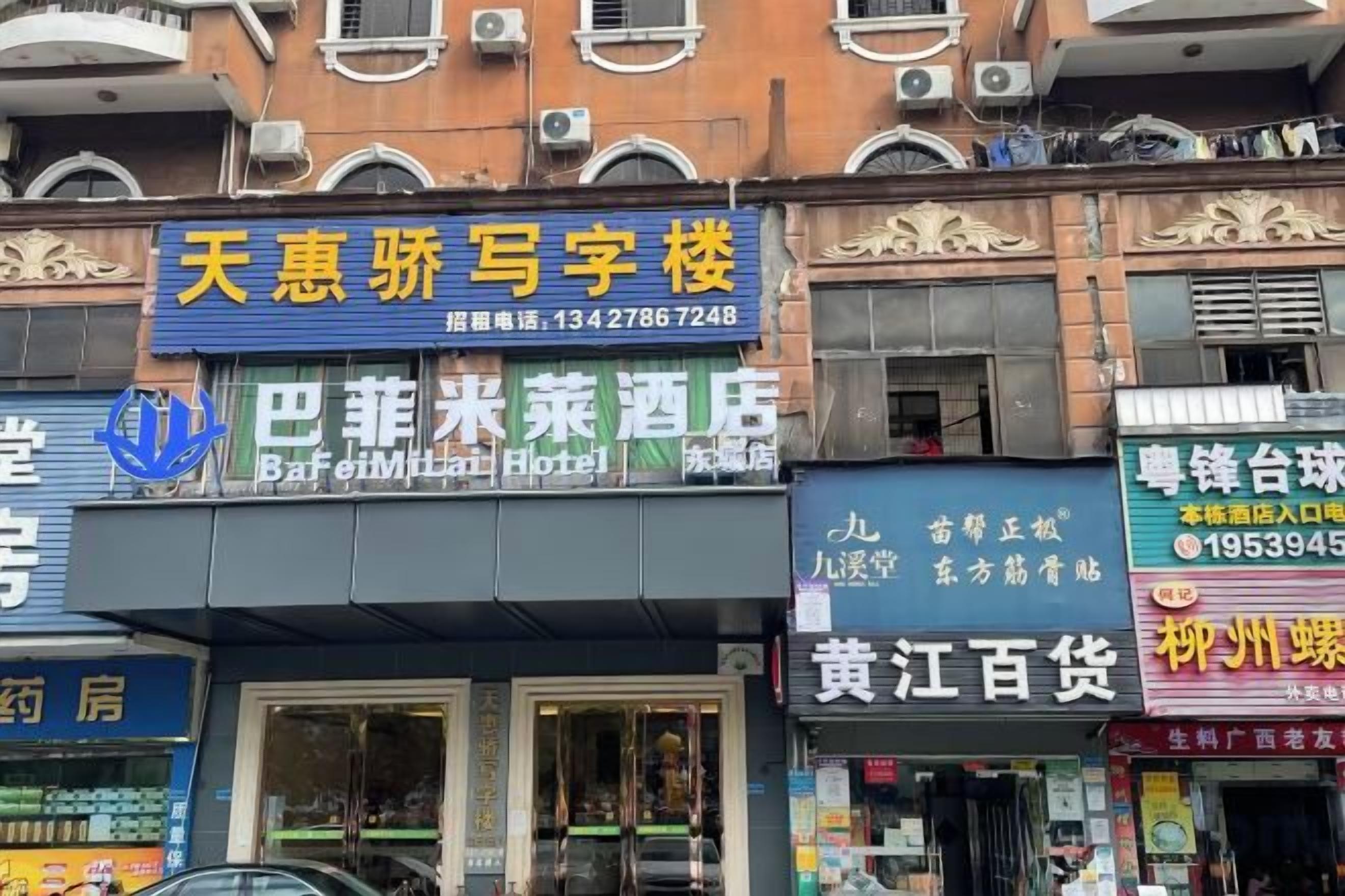 Een hotel met verschillende borden, waaronder een voor Baijiutai Hotel.