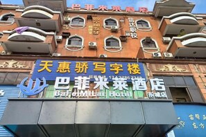 A hotel facade with signage for 'Baijiayuan Hotel' and 'Baijiayuan Hotel' in English.