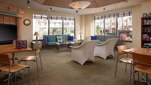 Une pièce spacieuse avec une grande télévision, des sièges confortables et une bibliothèque.