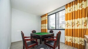 A room with a pool table, four chairs, and curtains with a pattern. - Yinlilai Business Hotel (Tianquan Hospital of Traditional Chinese Medicine Branch) (Tianquan)