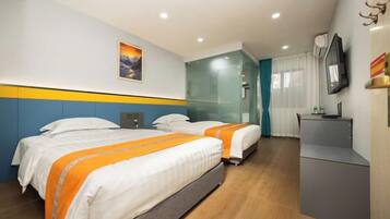 A hotel room with two beds, a desk, a TV, and a painting on the wall.