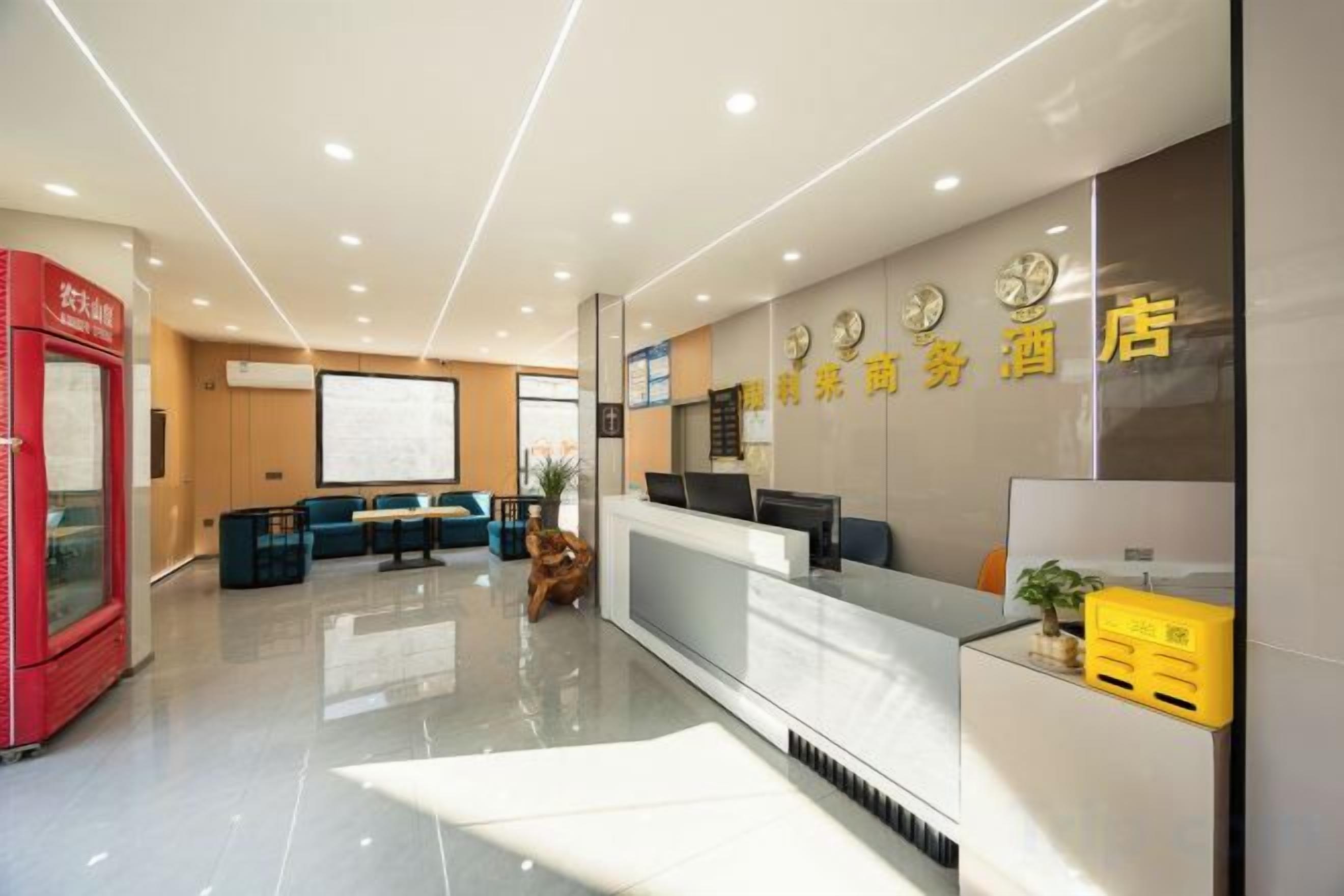 A hotel reception area with a reception desk, seating area, and a red vending machine.