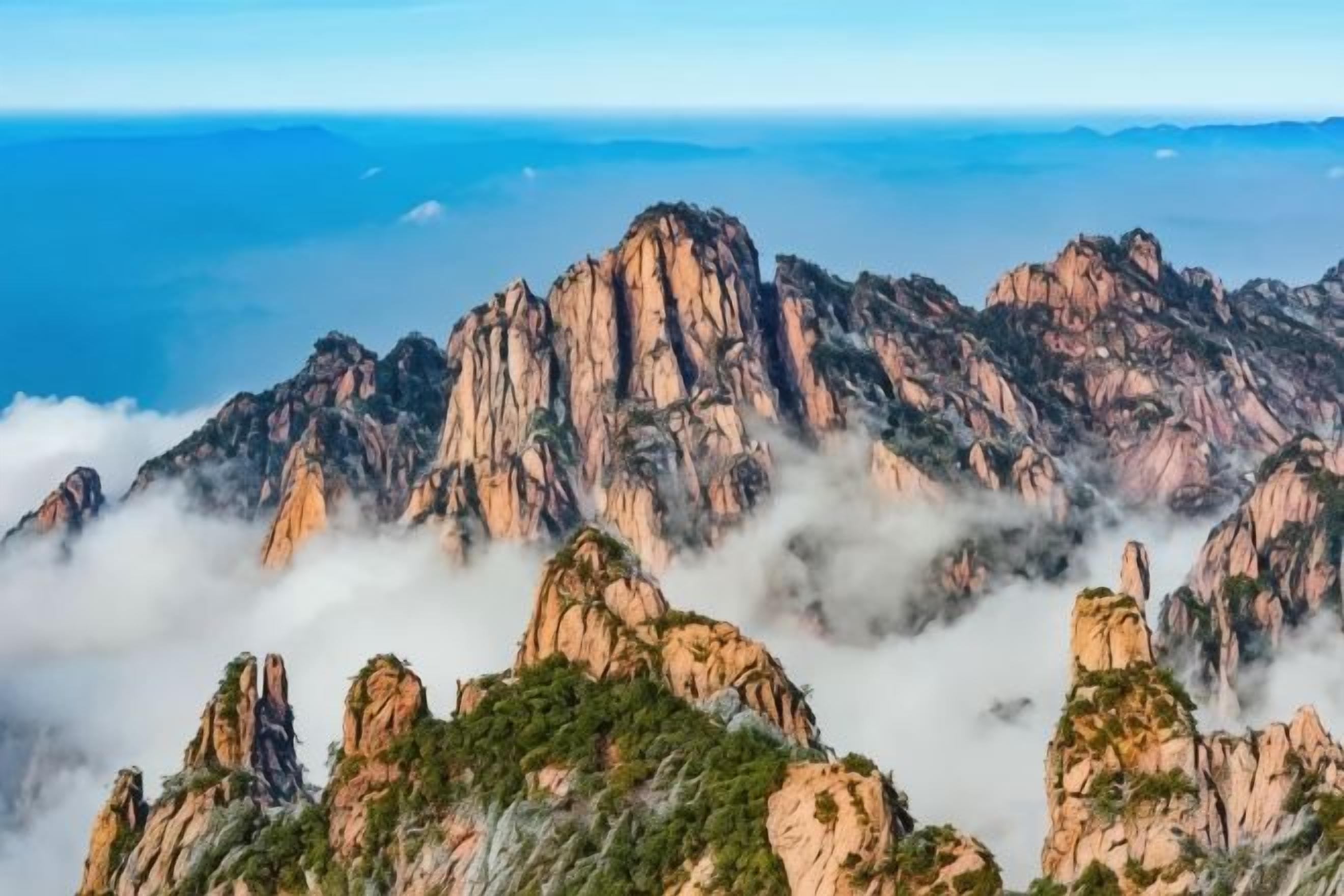 A mountainous landscape with rocky peaks and lush greenery.