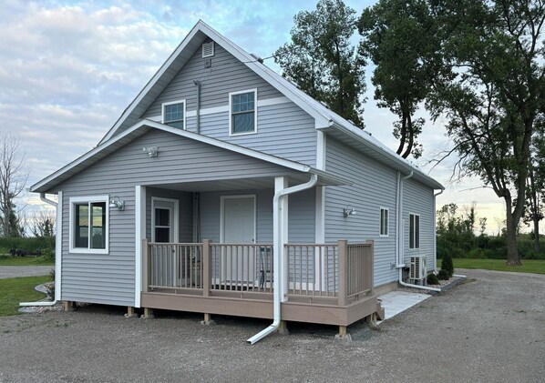 A single-story house with a front porch, a small deck, and a garage. - Spacious waterfront home recently remodeled with WiFi, AC, and cable TV. (Oconto)