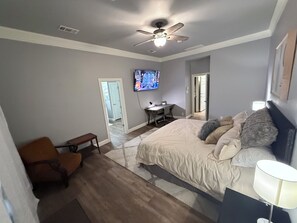 Cozy retreat with a large bed, flat-screen TV, and comfortable workspace.