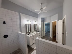 Bathroom features a double sink, mirror, and ceiling fan.