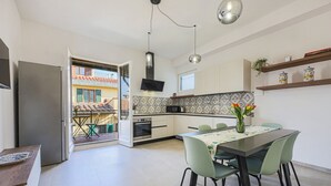 A modern kitchen with a dining area, a built-in oven, and a view of the outside.