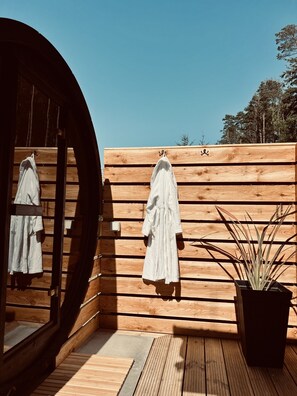 A wooden cabin with a large window and a wooden wall with a towel rack.