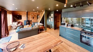 A cozy living room with a sofa, a dining table, and a kitchen area with cabinets and appliances.