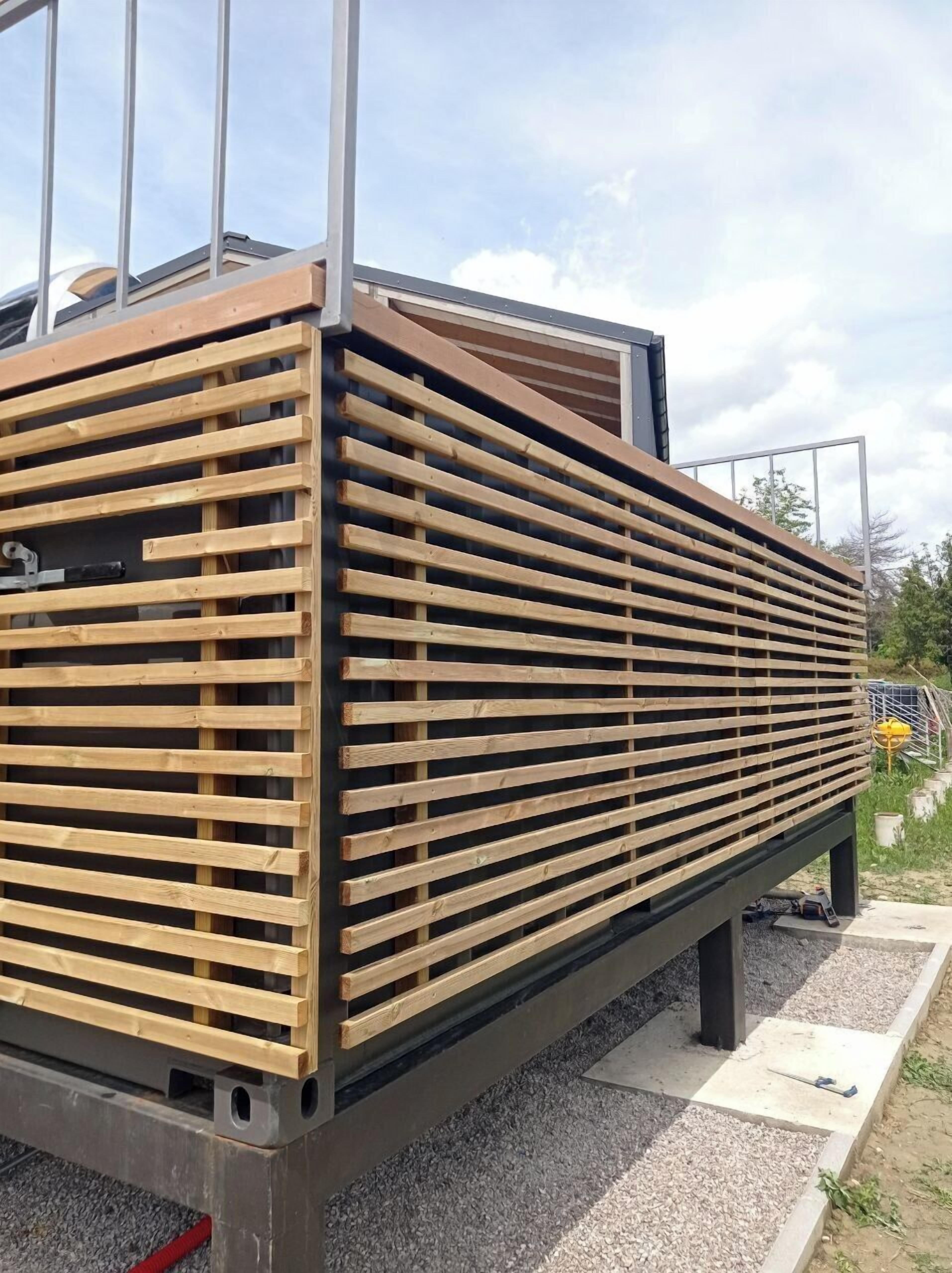 Un edificio moderno con fachada de madera con listones y estructura de metal.