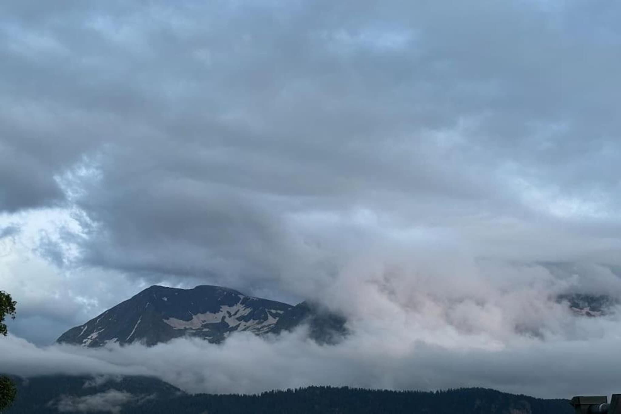 Montanha parcialmente coberta por nuvens.