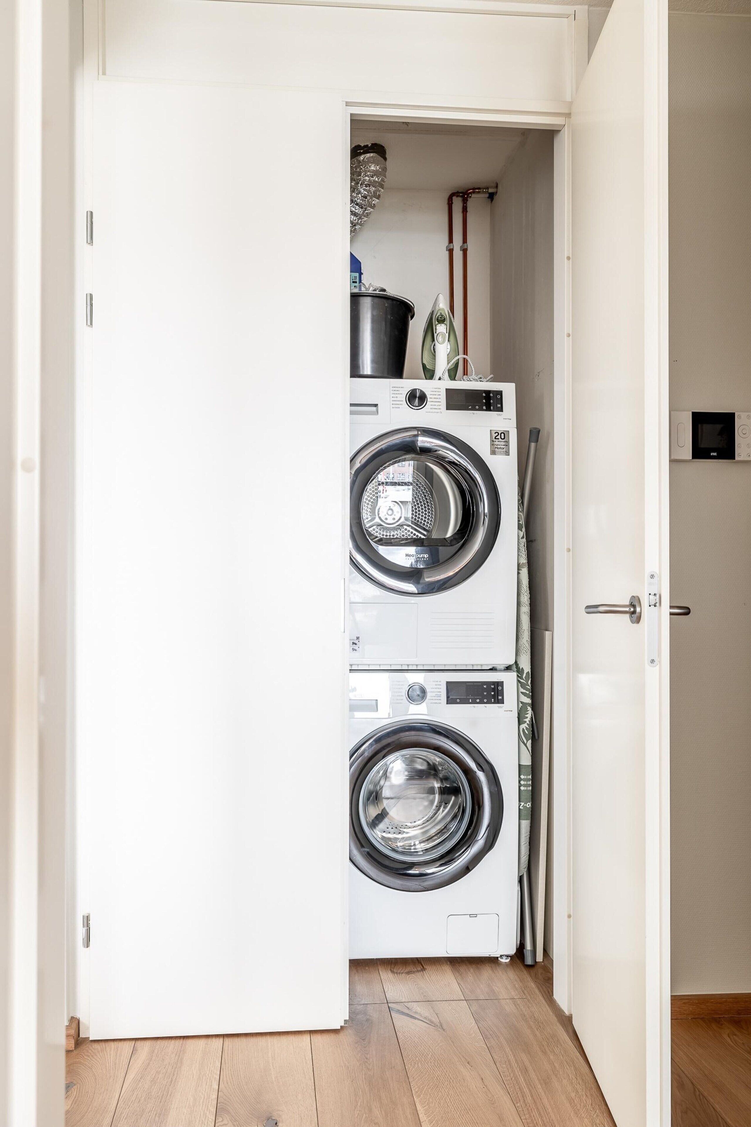 A laundry room with two stacked front-loading washing machines and a dryer.