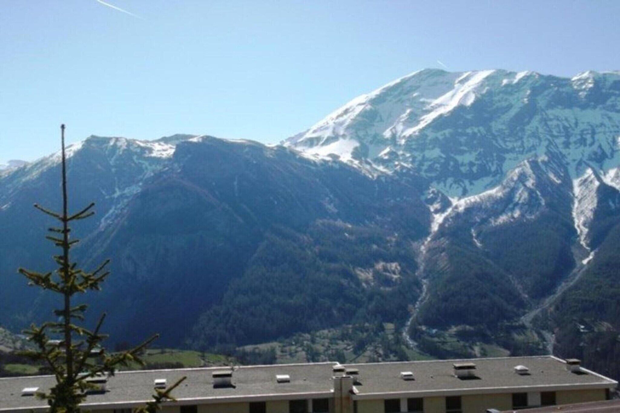 Un paysage de montagne avec un bâtiment au premier plan.