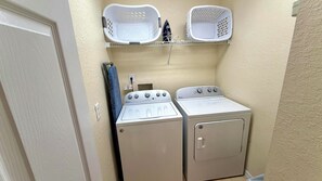 A laundry area with two washers and dryers, a towel rack, and two baskets on a shelf. - Highlands Reserve 4 Bed Pool Home with Spa - Golf Course Views (Davenport)