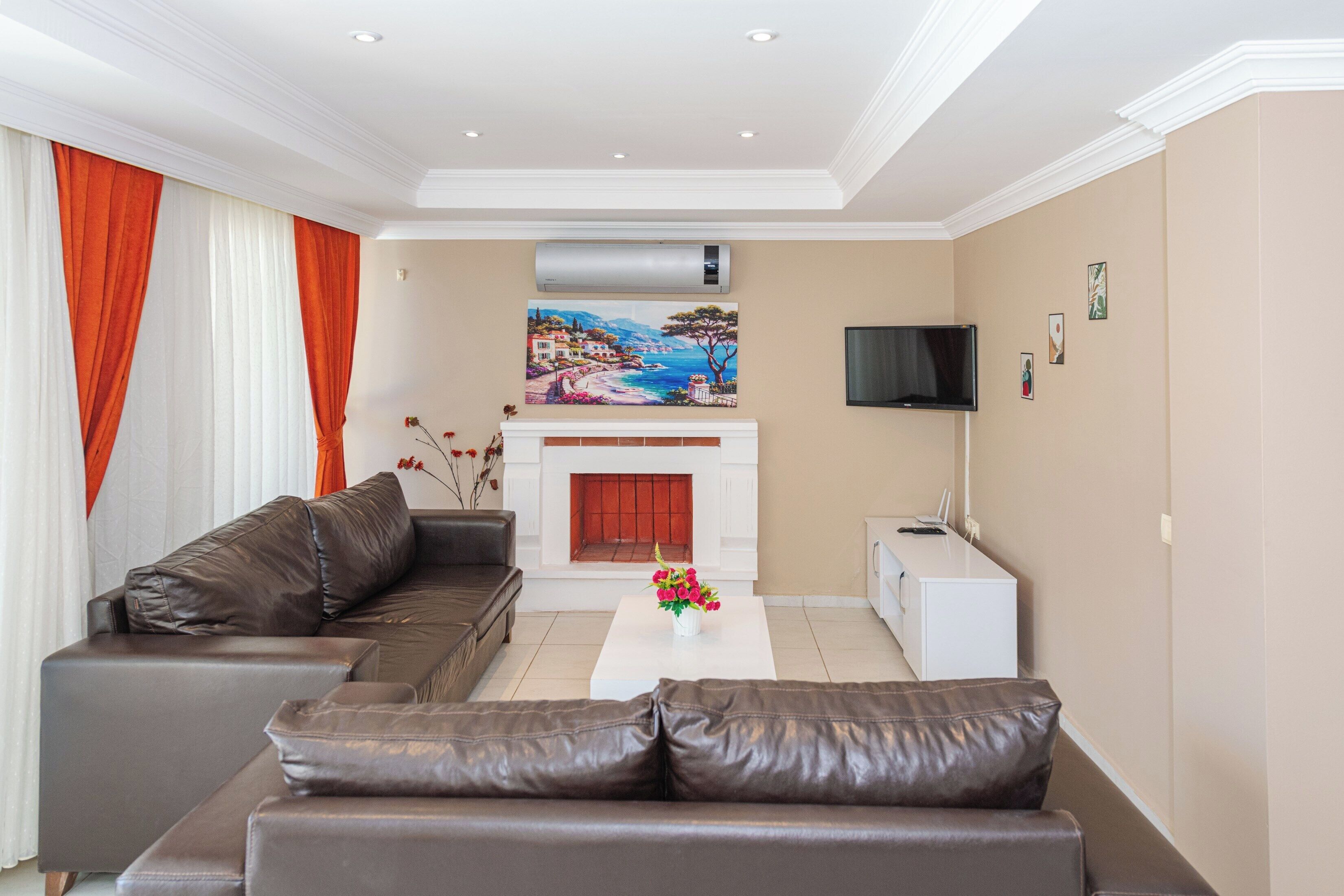 A modern living room with a sectional sofa, a fireplace, and a flat-screen TV.