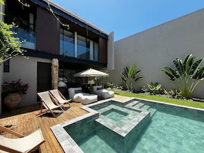 A modern outdoor pool area with a geometric design, surrounded by a wooden deck and lounge chairs. - Casa Alma - By Living Milagres (Passo de Camaragibe)