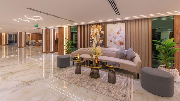 Eine moderne Lobby mit einer Couch, einem Couchtisch und Topfpflanzen.