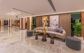 Un hall d’entrée moderne avec un canapé, une table basse et des plantes en pot.