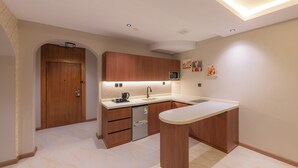Eine moderne Küche mit Holzschränken, einem eingebauten Geschirrspüler und einer weißen Arbeitsplatte.