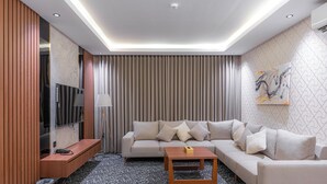 Ein modernes Wohnzimmer mit einer Couch, einem Couchtisch, einem Fernseher und einem Gemälde an der Wand.