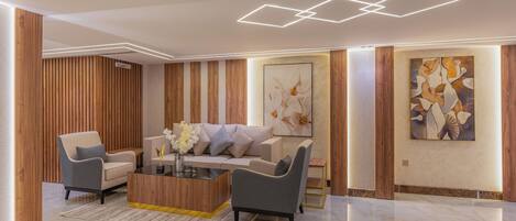 A modern living room with a sofa, armchairs, a coffee table, and a decorative wall piece.
