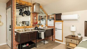 Une cuisine compacte équipée d’une cuisinière à gaz, d’un four et d’un réfrigérateur Galanz.