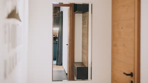 A narrow hallway with a wooden door on the right and a small window on the left. - Apartments Niederseer - Reiterkogel (Saalbach)
