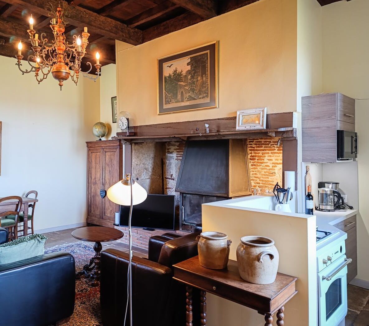 A rustic kitchen with a brick wall, wooden cabinets, a built-in oven, and a hanging light fixture.