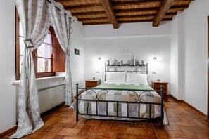 Een slaapkamer met een bed, een houten hoofdbord en stadsgezicht kunst aan de muur.