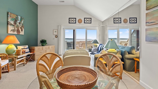 A living room with a dining area, large windows, and a view of the landscape. - Beachfront w/ Breathtaking Views! 1BR/2BA, Pet Friendly, Amenity Access included (Seabrook Island)