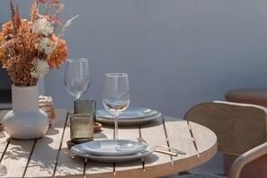 A table set with plates, glasses, and a vase of dried flowers. - WELCS APARTAMENTO 223 EMP con TERRAZA con VISTA (Empuriabrava)
