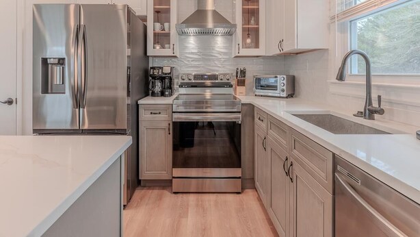 Una cocina moderna con electrodomésticos de acero inoxidable, armarios de madera y un ventanal que proporciona luz natural.