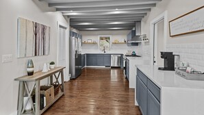 A modern kitchen with grey cabinets, a stainless steel refrigerator, and a coffee station. - Elevation Escape - Beech Mtn home with game room, outdoor space (Beech Mountain)