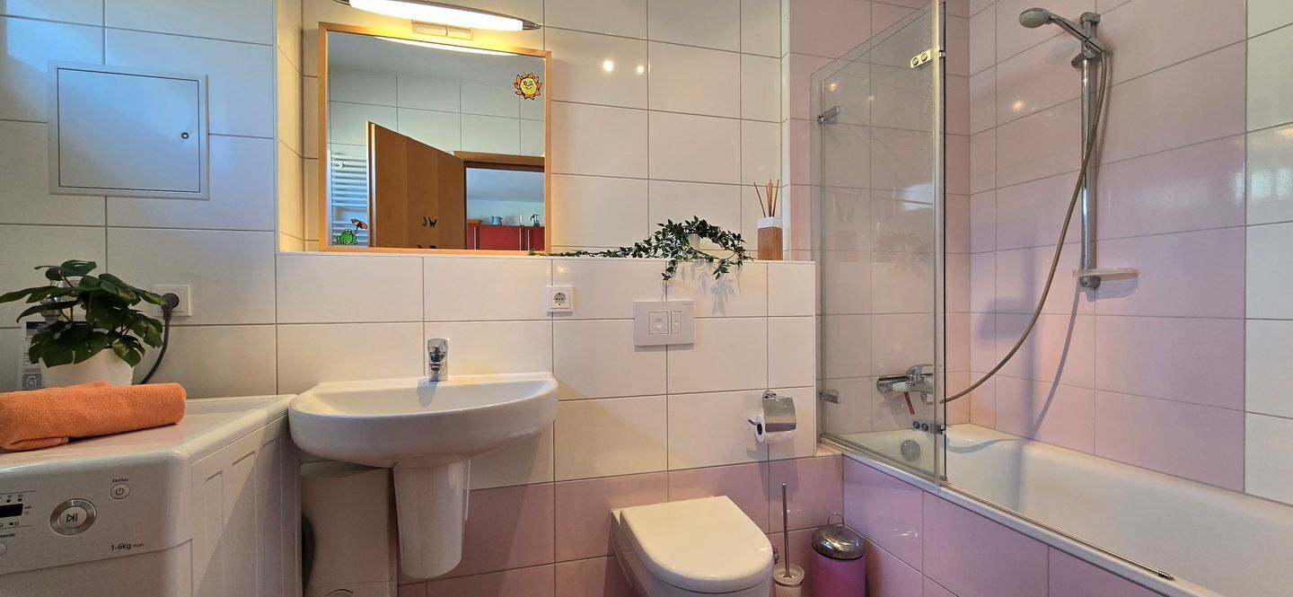 A modern bathroom with a sink, toilet, and shower.