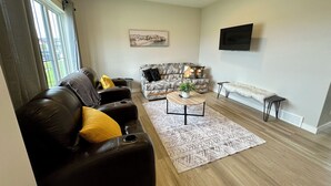 A modern living room with a leather sofa, patterned armchair, and a coffee table.