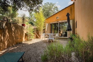 A patio with a table and chairs, a covered area, and a gravel ground. - Holiday Home 'La Poulido' with Private Terrace, Private Garden and Wi-Fi (Bedoin)