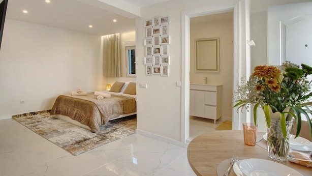 A bedroom with a bed, bedside table, and a nightstand.