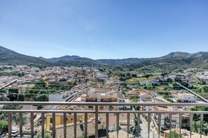 Un balcon avec vue sur la ville et les montagnes.