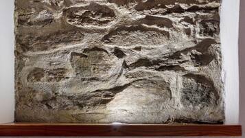 Un mur en pierre à la texture particulière, avec une base en bois.