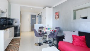 Une cuisine moderne avec un coin repas, un canapé et un miroir au mur.