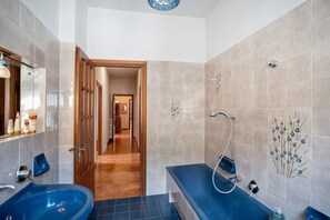 A bathroom with a blue sink, a bathtub, and a shower.
