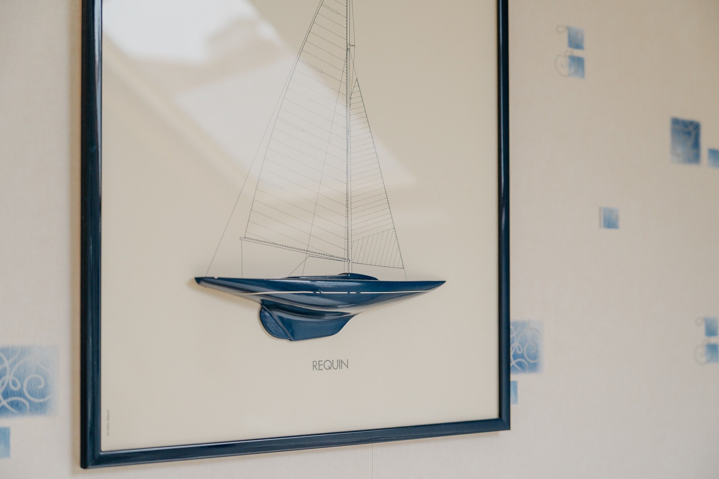 A framed architectural drawing of a sailboat with the word 'REQUIN' below it.