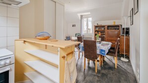 A compact kitchen with a dining area, a built-in oven, and a window providing natural light.