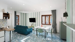 A modern kitchen with a dining area, a sofa, and a TV. - Apartment 'Monolocale A Due Passi Dagli Scavi' with Mountain View, Wi-Fi and Air Conditioning (Ercolano)